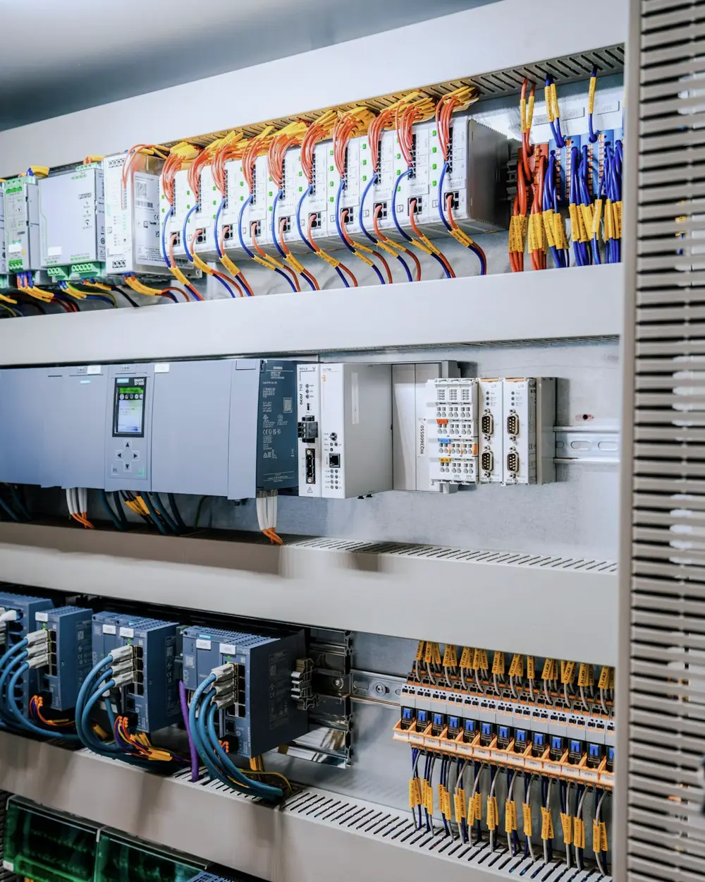 Tablero eléctrico abierto con controladores, relés y cableado